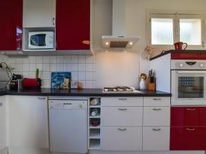 a kitchen with red and white cabinets and appliances at Seaside Comfort in Erquy in Erquy