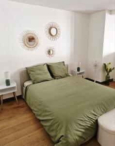 a bedroom with a bed and two mirrors on the wall at Studio 11 in Sète