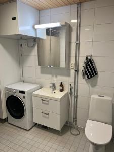a bathroom with a washing machine and a sink at Quality dreams - modern two-room apartment - private parking in Turku