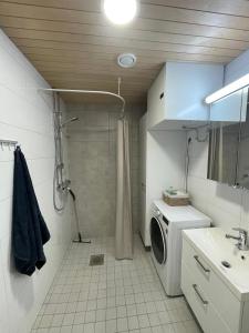 a bathroom with a shower and a washing machine at Quality dreams - modern two-room apartment - private parking in Turku +2 photos