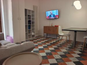 a living room with a table and a tv on a wall at Appartamento via Benaducci Foligno in Foligno