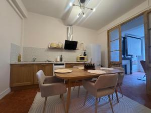 una cucina con tavolo e sedie in una cucina di Le Régent - Perpignan city center a Perpignano Altre 25 foto