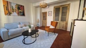 un soggiorno con un divano, un tavolo e delle sedie di Le Régent - Perpignan city center a Perpignano