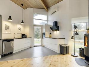 a kitchen with white cabinets and a large window at 8 person holiday home in Væggerløse in Marielyst +21 photos
