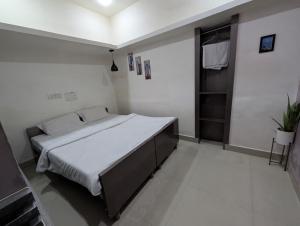 a bedroom with a large bed in a white room at Hotel Indra Palace in Damoh