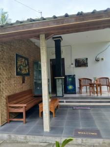 a patio with a wooden bench and a stove at TebaFamily in Blahbatu