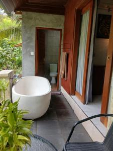 a bath tub sitting outside of a bathroom with a toilet at TebaFamily in Blahbatu