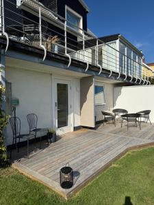 a wooden deck with benches and tables on a house at Nyrenoverad 2-rummare med gratis laddning för elbil in Bankeryd