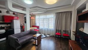 a living room with a couch and a kitchen at Apartment on Nazarbayeva 77 in Almaty