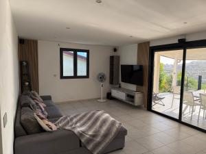a living room with a couch and a television at Villa Principauté in Fort-de-France