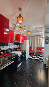 a kitchen with red cabinets and black counter tops at Apartment on Nazarbayeva 77 in Almaty +13 photos