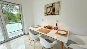 a white dining room with a white table and chairs at Himy Home - Moderne Wohnung mit große Dachterrasse in Dormagen