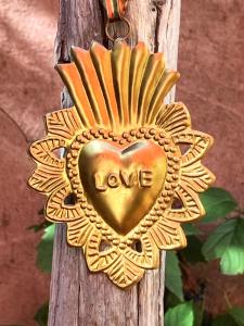 a gold heart shapedendant with the word love on it at Les Cailloux Dorés in Massillargues-Attuech