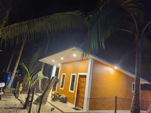 a small yellow house with a palm tree at Orange House in San Juan +2 photos