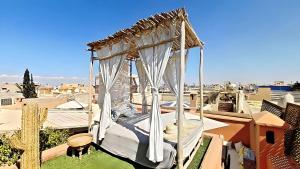 a canopy bed on top of a roof at Riad El Grably in Marrakesh