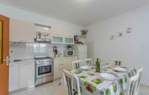 a kitchen with a table and chairs and a kitchen with a table and chairsktop at Damir in Dajla