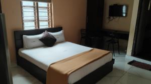 a bedroom with a bed with white sheets and pillows at Tamar Residancy in Padinjarathara