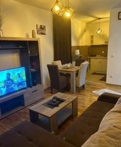 a living room with a couch and a table with a television at Power in Belgrade