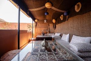 Habitación con cama y mesa de cristal. en Riad Chams Marrakech, en Marrakech