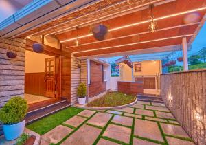 a house with a patio with plants and lights at Villa Terra Verde Ooty by VOYE HOMES in Ooty