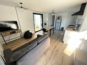 a living room with a couch and a table at la pause landaise in Saint-Vincent-de-Paul