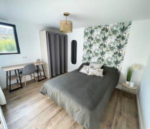 a bedroom with a large bed and a desk at la pause landaise in Saint-Vincent-de-Paul