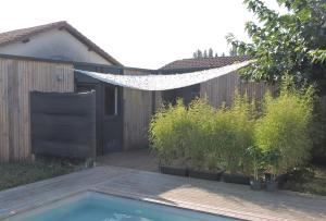 a hammock is hanging over a fence in a backyard at la pause landaise in Saint-Vincent-de-Paul