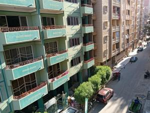 un immeuble d'appartements avec des balcons verts dans une rue de la ville dans l'établissement لؤلؤه العوام, à Marsa Matruh
