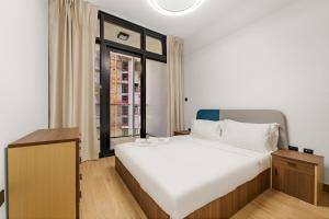 a bedroom with a large white bed and a window at FIRST CLASS 1BR Waterfront Bliss in Abu Dhabi +23 photos