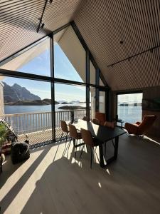 un soggiorno con tavolo e sedie su un balcone di CornerView Apartment Henningsvær a Henningsvær