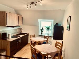 a kitchen with a table and chairs and a kitchen with a sink at Gästezimmer Bruno in Bremm