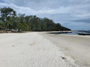 a sandy beach with trees in the distance at Beach House in Chaloklum