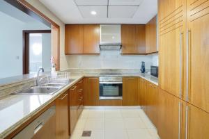 a kitchen with wooden cabinets and a sink at 13Stnd- Luxury Living in Downtown Near Burj Khalifa & World Trade Center in Dubai