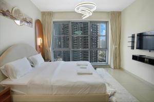 a bedroom with a large white bed and a large window at 13Stnd- Luxury Living in Downtown Near Burj Khalifa & World Trade Center in Dubai