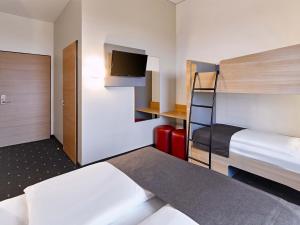 a hotel room with a bunk bed and a tv at B&B Hotel Köln-Troisdorf in Troisdorf