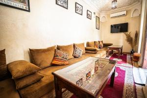 una sala de estar con un sofá y una mesa en Riad Chams Marrakech, en Marrakech