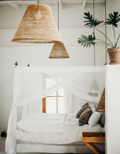 a bedroom with a white canopy bed with pillows at Watsonia Cottage at Waboom Family Farm in Stanford