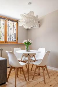une salle à manger avec une table et des chaises blanches dans l'établissement Apartment with Fireplace in Old Tbilisi, à Tbilissi