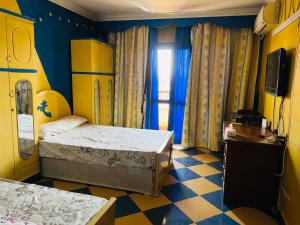 Zimmer mit 2 Betten und einem TV. in der Unterkunft Cleopatra hostel -埃及艳后 民宿 in Kairo