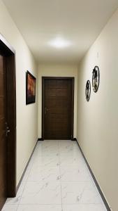 a hallway with a door and a tile floor at Nvista Luxe Living in Islamabad
