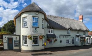 a large white building with a thatched roof at Blue Ball Inn, Sandygate, Exeter in Exeter