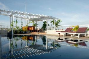 a swimming pool with two chairs and a pergola at Day Sunrise Boutique Hotel in Siem Reap