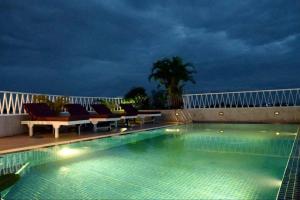 a swimming pool at night with chairs and the ocean at Day Sunrise Boutique Hotel in Siem Reap
