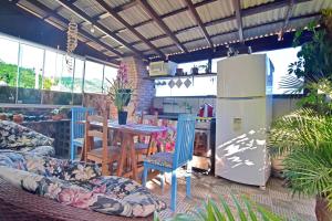 Una cocina con refrigerador y una mesa con sillas. en Floripa espaço independente com próx Centro e UFSC, en Florianópolis