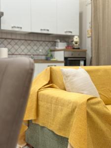 a yellow blanket on a couch in a kitchen at Casa Vacanza da Rosy in Boscotrecase
