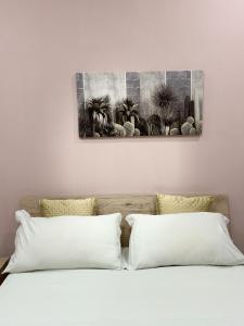 a bed with two pillows and a painting on the wall at Casa Vacanza da Rosy in Boscotrecase