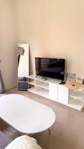 a living room with a white table and a tv at White Pearl 2BR Beachfront House Malibu Seaview in Mae Haad