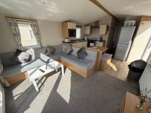 a living room with a couch and a table at Palm Grove 181- Golden Palm - Pet friendly, WiFi, central heating, bed linen - Meadow Lakes Caravan & Lodge Hire in Chapel Saint Leonards