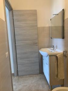 a bathroom with a shower with a sink and a mirror at CASA VACANZE gli ULIVI 23 in Sìnnai +28 photos
