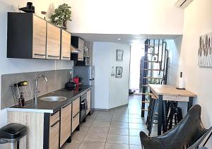 a kitchen with a sink and a table in it at Douceur du sud in Vitrolles